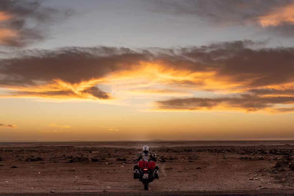 Mit dem Motorrad in den Sonnenaufgang fahren, Western Sahara. Foto: Lea Reck