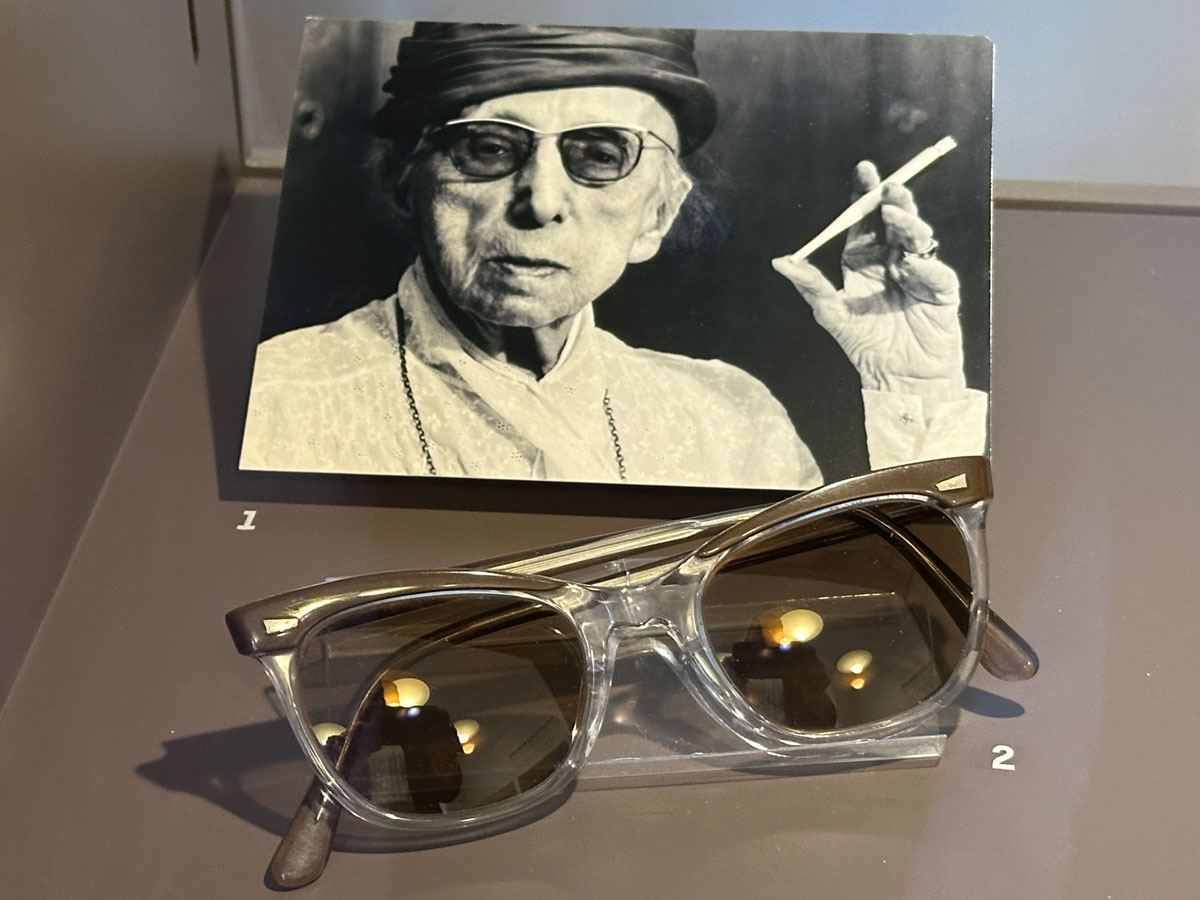 Blick in Ausstellungsvitrine: Annette Kolb mit Hut, Sonnenbrille und Zigarette. «Literarisches München zur Zeit von Thomas Mann» Monacensia