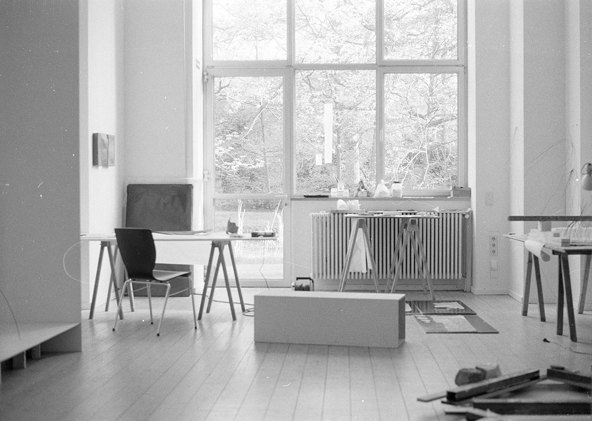 Atelieransicht von Miriam Salamander mit Tisch, Stuhl und Werken, schwarz-weiß-Aufnahme