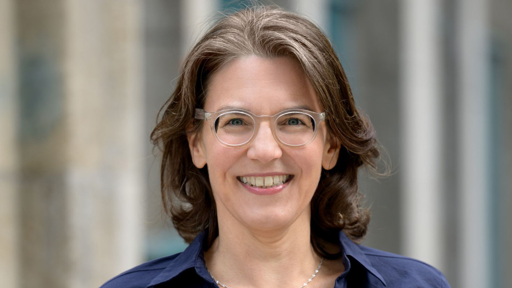 Frau mit Brille lächelt in die Kamera