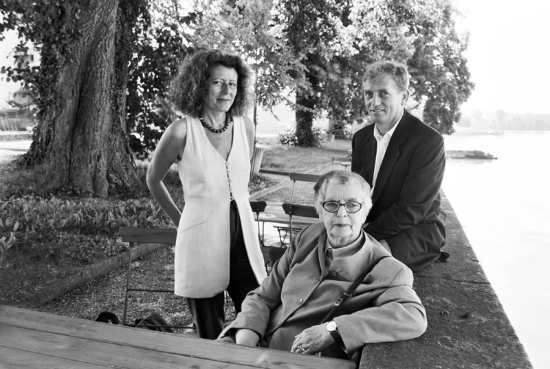 Drei Menschen, eine ältere Frau sitzend mit Brille, links davon mittelalte Frau mit Schulter langem Haar, und rechts auf der Mauer sitzend ein jüngerer Mann: Rachel Salamander, Hanne Lenz und Arnold Stadler.
