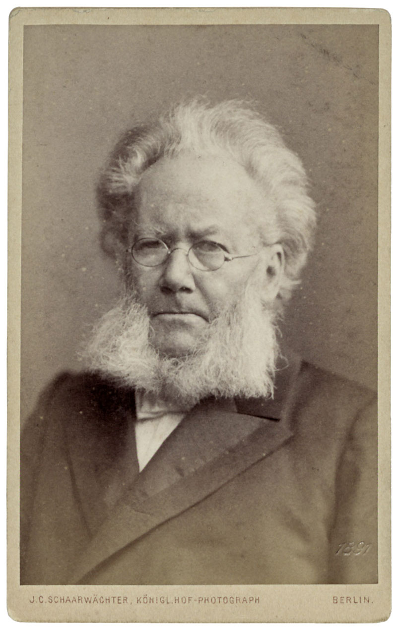 Historische Portraitfotografie: Älterer Mann mit Baar und Brille im Anzug mit Fliege blickt in die Kamera: Henrik Ibsen