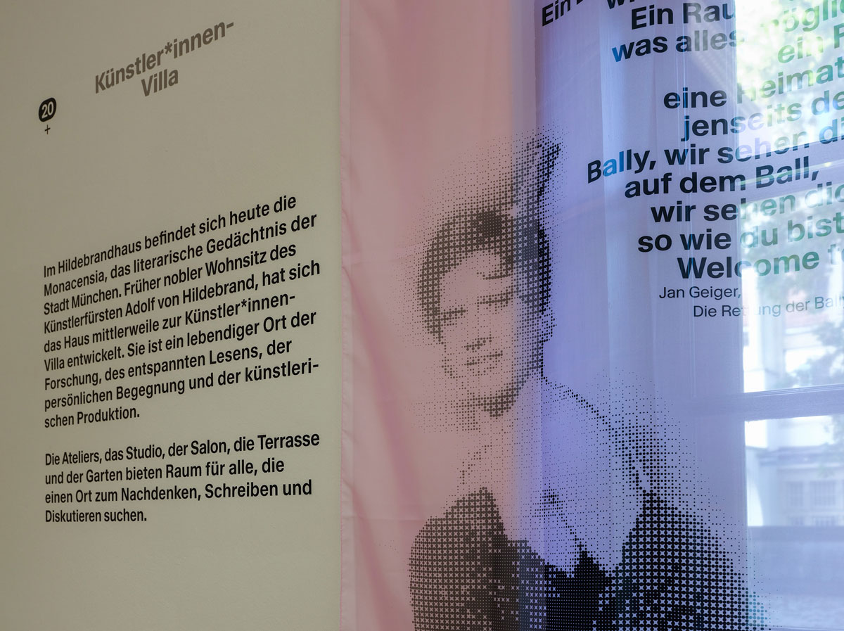 Blick auf Wand im MON_Studio der Künstler*innen-Villa mit Vorhang mit Vicky Voyage als Bally Prell.