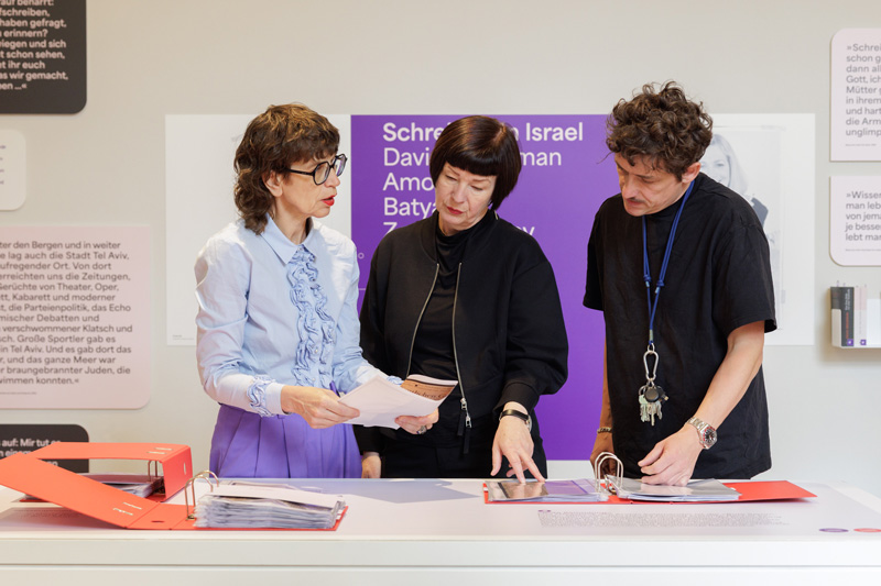 Zwei Frauen, ein Mann an einem Tisch mit Ordnern: Anke Buettner, Sylvia Schütz, Patrick Geiger.