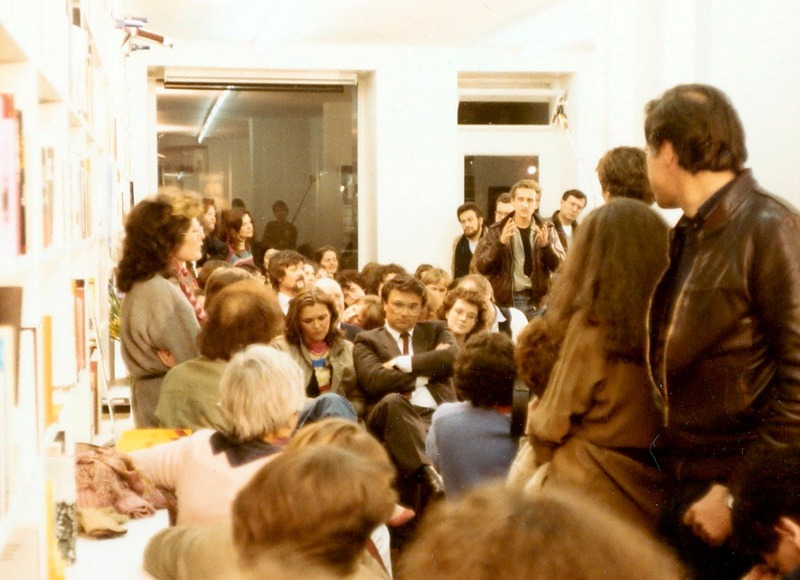 Sitzende und stehende Menschen, die zuhören und diskutieren. Literaturhandlung