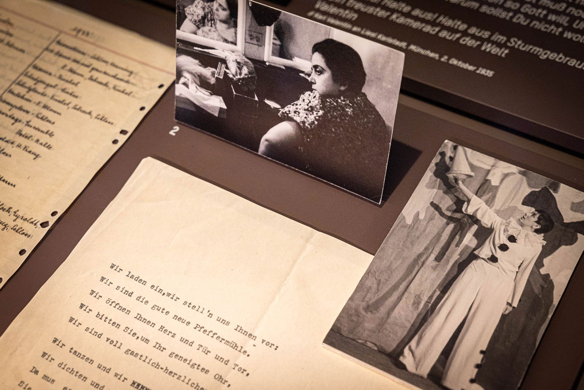 Blick in die Vitrine der Ausstellung «Literarisches München zur Zeit von Thomas Mann» mit Erika Mann als Harlekin in der «Pfeffermühle», begleitet von einem Textauszug und Therese Giehse im Hintergrund. © Monika Schreiner