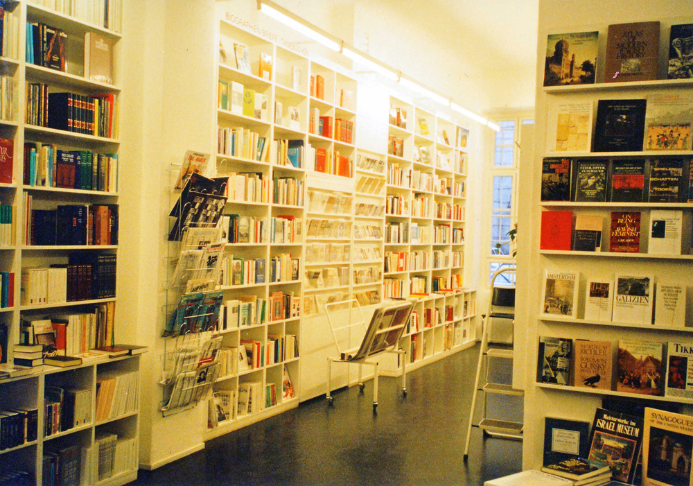 Blick in eine Buchhandlung mit Büchern befüllte, weiße Regale: Literaturhandlung Berlin.