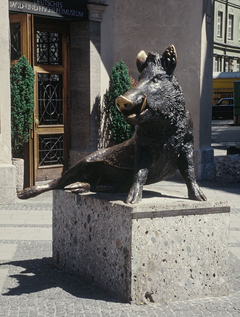 Sitzender Keiler, Bronzeskulptur von Martin Mayer vor dem Eingang des Deutschen Jagd- und Fischereimuseums.