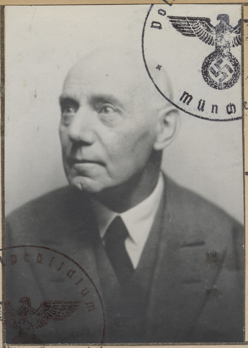 gestempeltes scharz-weiß Foto von einem älteren, kahlköpfigen Mann, der nach rechts blickt in Anzug und mit Krawatte: Otto Manasse.
