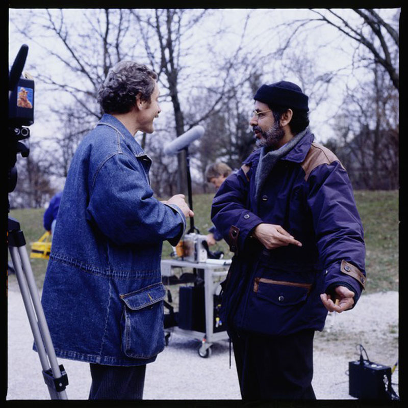 Zwei Männer beim Filmdreh im Gespräch einander zugewandt im Herbst: Eberhard Scheu und Sohrab Shahid Saless, Anfang 1991 bei den Dreharbeiten zum Fernsehfilm Rosen für Afrika