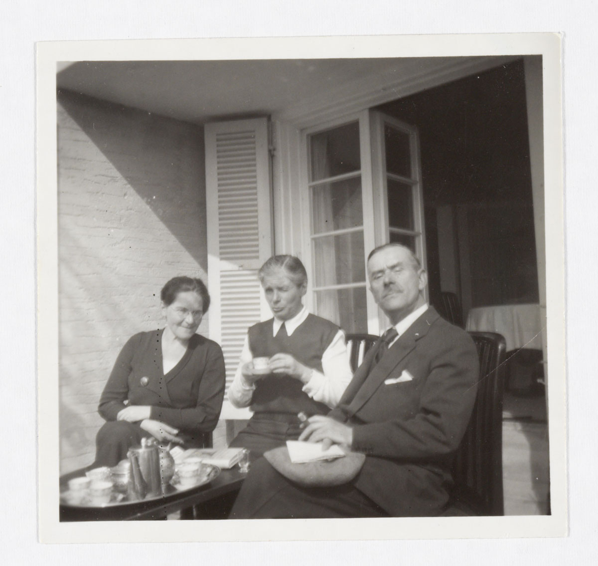 drei Personen beim Café sitzend: Ida Herz, Katia Mann und Thomas Mann