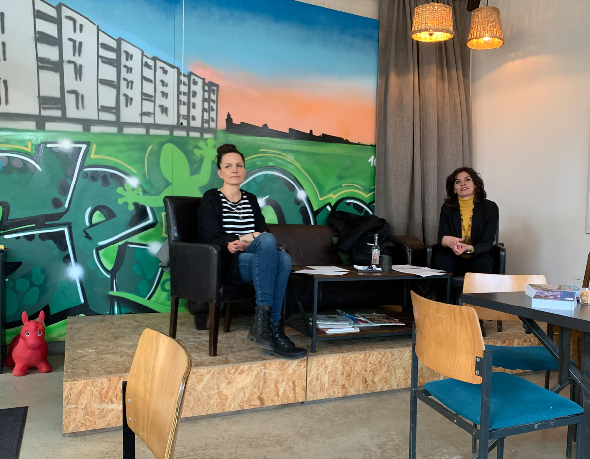 Mara Roth und Serena D'Auria sitzen auf Podium im Café GeQo zum Erzählcafé