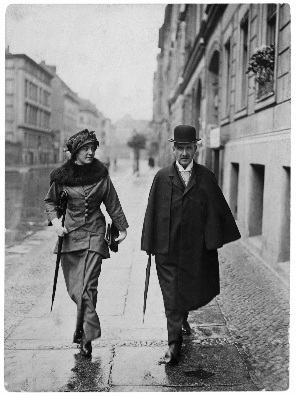 Tilly und Frank Wedekind gehen mit Regenschirm auf der Straße. Herbst 2025 - Ausstellung "Literarisches München zur Zeit von Thomas Mann", Monacensia