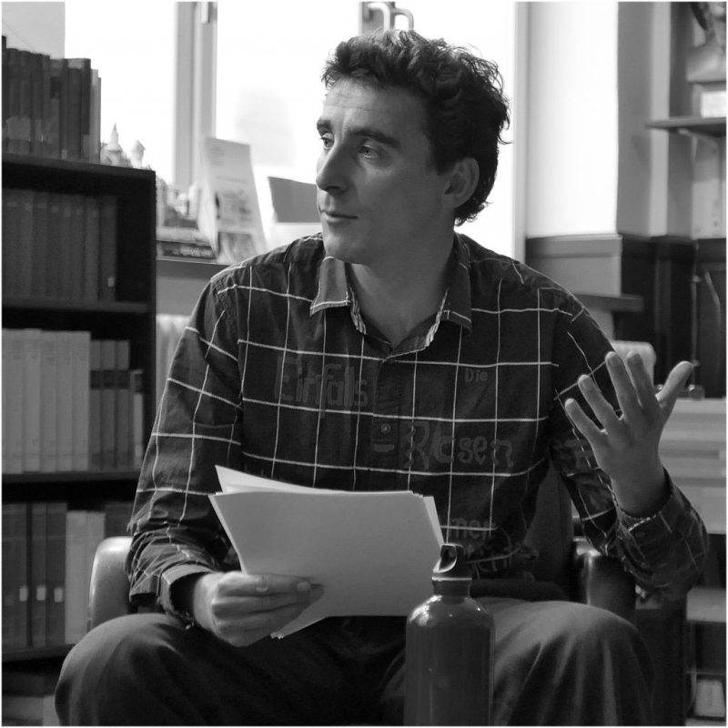 Jonas Bokelmann liest aus einem Script in einer Buchhandlung.