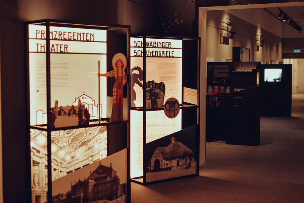 Blick in die Ausstellung "Kunst und Bühne. Spielorte des Münchner Jugendstils." mit Vitrine und Exponaten