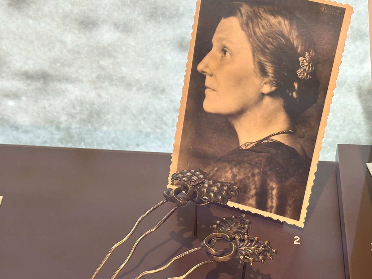 Foto von Lena Christ, davor ihre Haarnadeln. in Ausstellungsvitrine der Monacensia "Literarisches München zur Zeit von Thomas Mann".