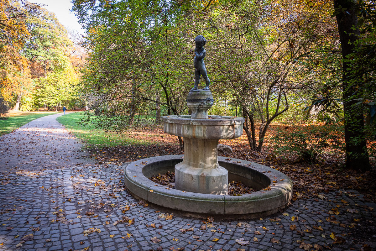 Brunnen mit bronzenen Knabenfigur bekrönt im Garten. #MeinBogenhausen.