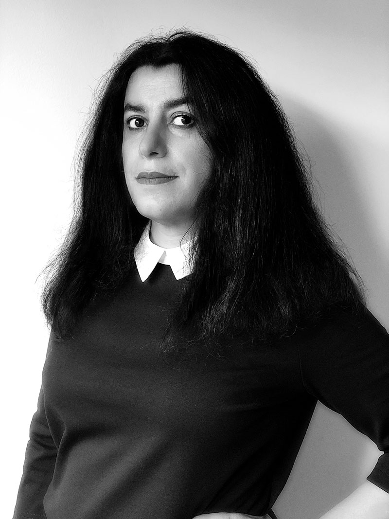 schwarz-weiß-Fotografie: Frau mit dunklen, brustlangen Haaren im 3/4 Profil, blickt in die Kamera: Marjane Satrapi.