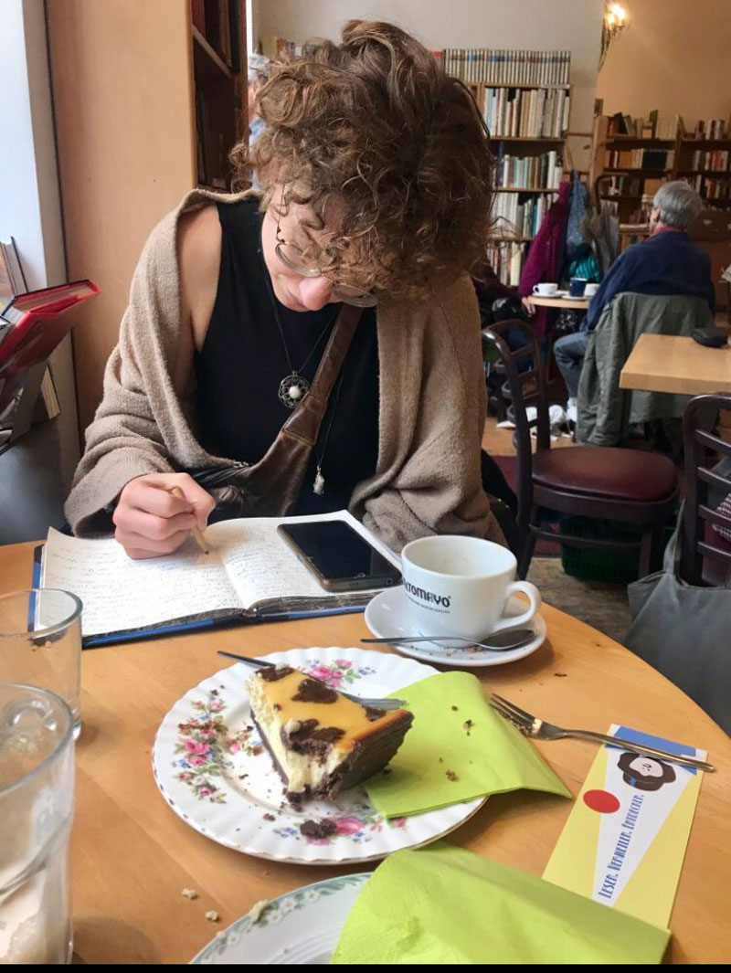 Lara Wüster schreibend im Café bei Kaffee und Kuchen. Münchner Kaffeehauskultur, #LiterarischesMuenchen