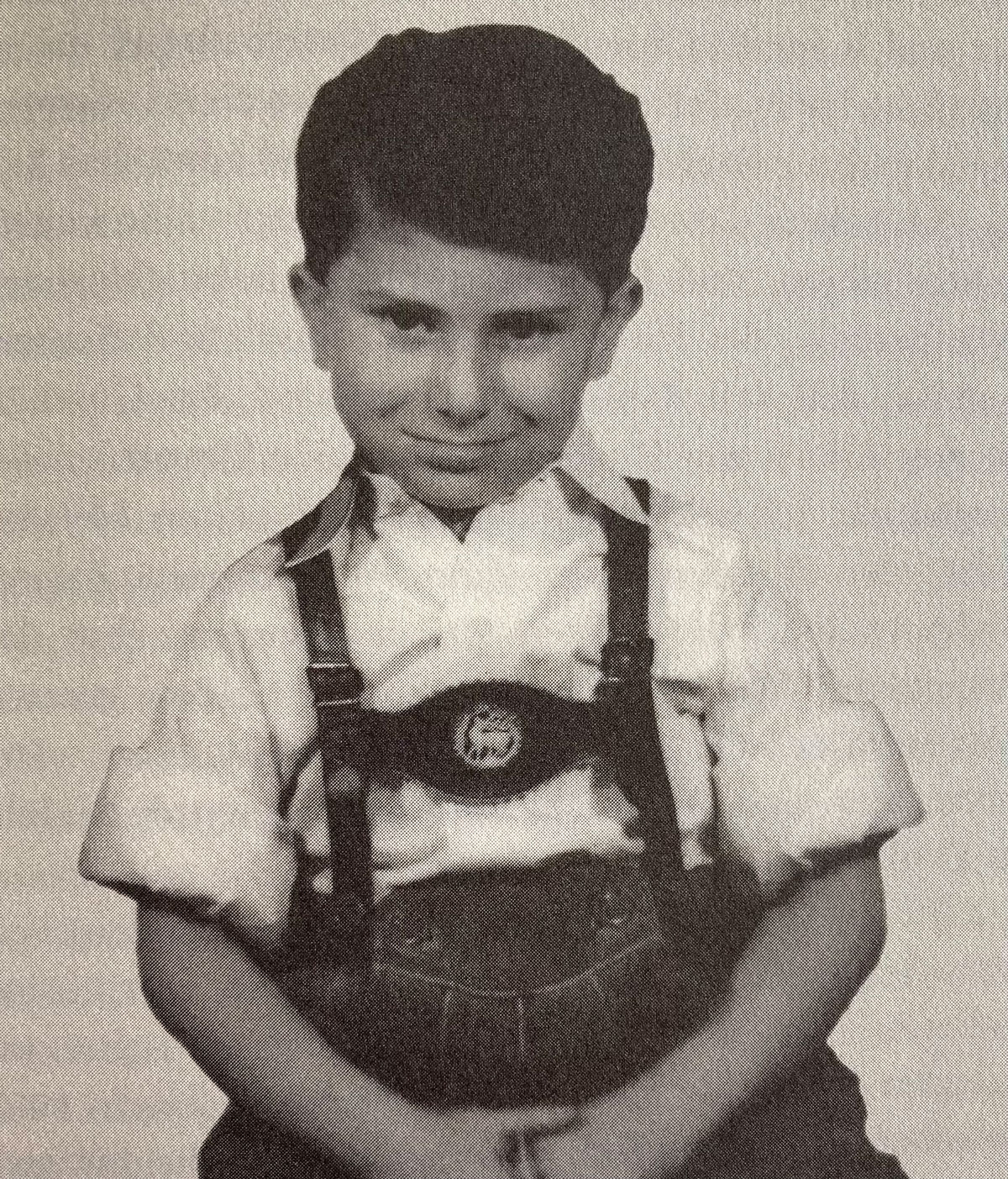 Roman Haller als Kind in Lederhose sitzend.