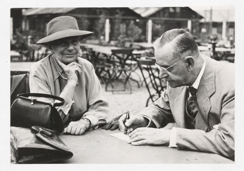 Katia und Thomas Mann am Tisch sitzend am Flughafen Kloten bei Zürich, vor Abflug nach London, 17.08.1950. Thomas Mann schreibt.
