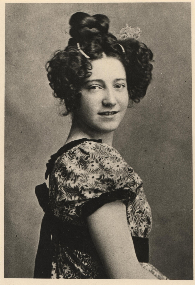 Historisches Foto: Frau in Kleid mit Hochsteckfrisur im Profil blickt in Kamera: Tilly Wedekind.