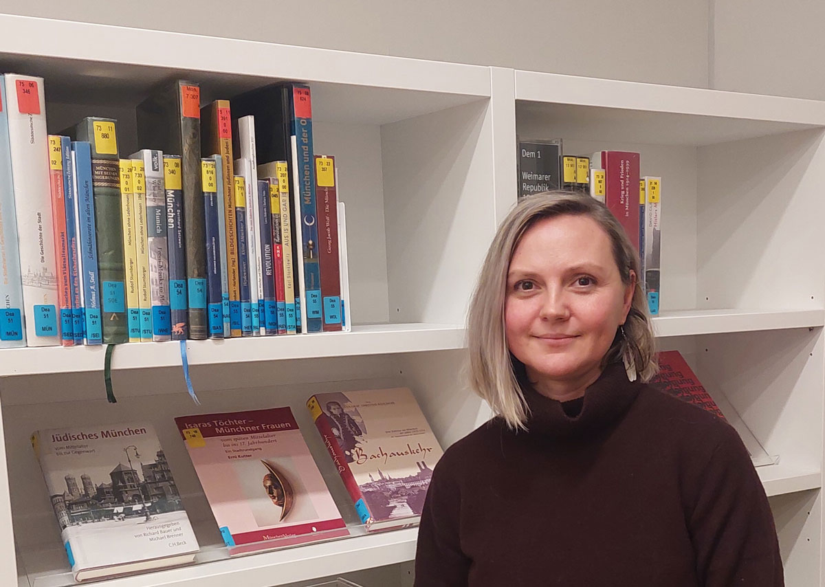 Volha Hapeyeva vor einem Bücherregal in der Monacensia