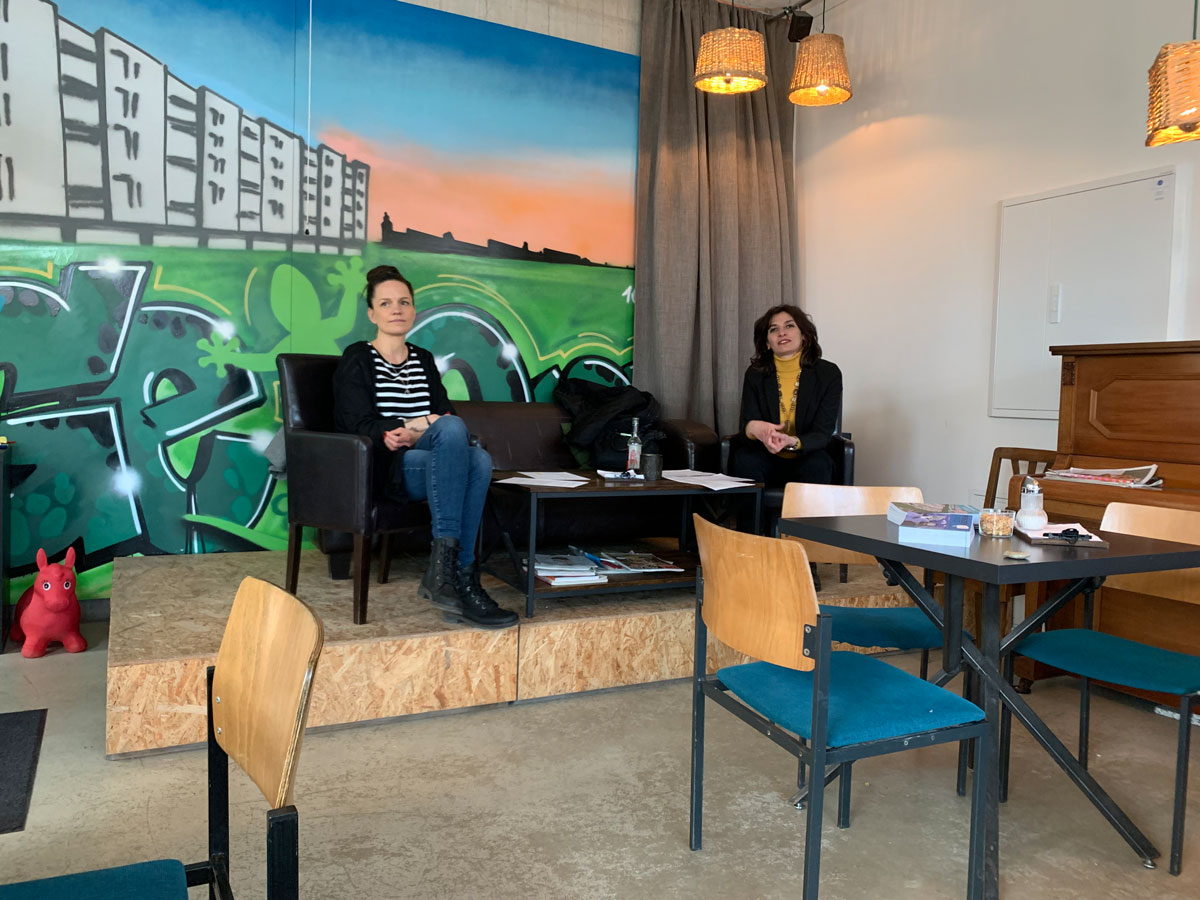 Mara Roth und Serena D'Auria sitzen auf Podium im Café GeQo zum Erzählcafé